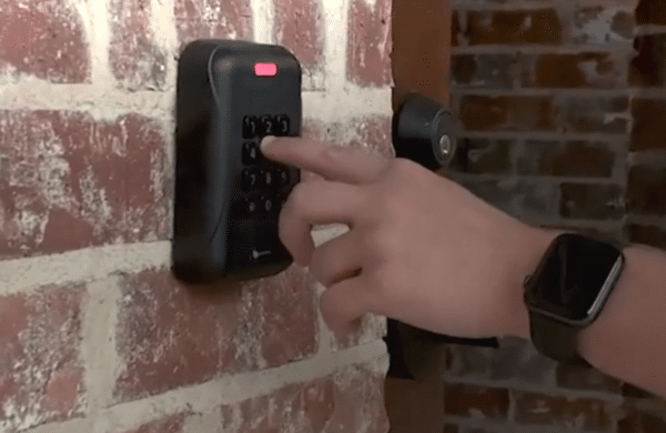Photo of someone interacting with a door-locking security interface